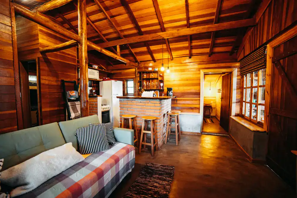 A cosy lodge interior featuring a roaring fire and heavy blankets