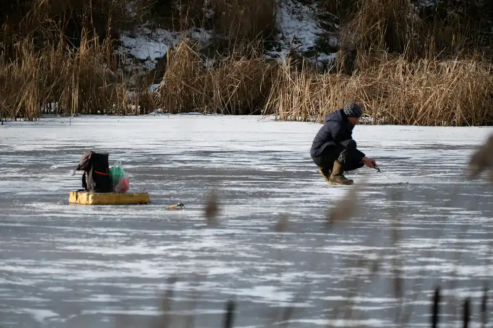 Guest enjoying an ice fishing session on the frozen lake